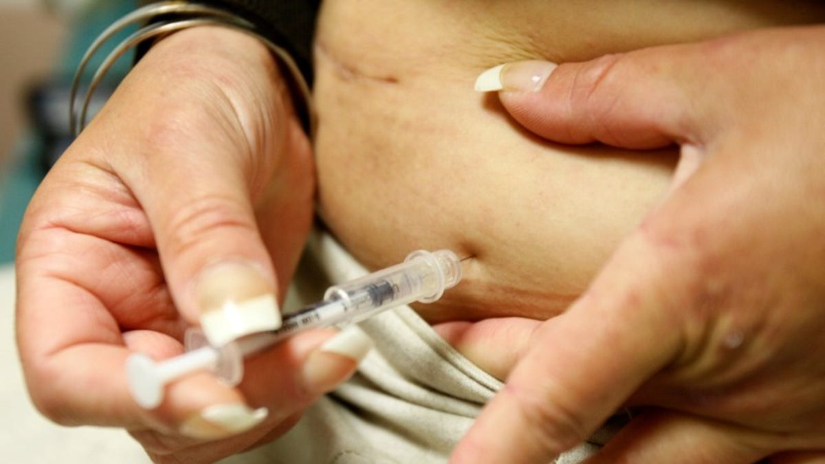 Diabetic Khachatoorian injects herself with insulin at the J.W.C.H. safety-net clinic in downtown Los Angeles