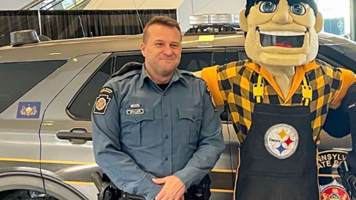 Benjamin Brallier stands next to a Pittsburgh Steelers mascot