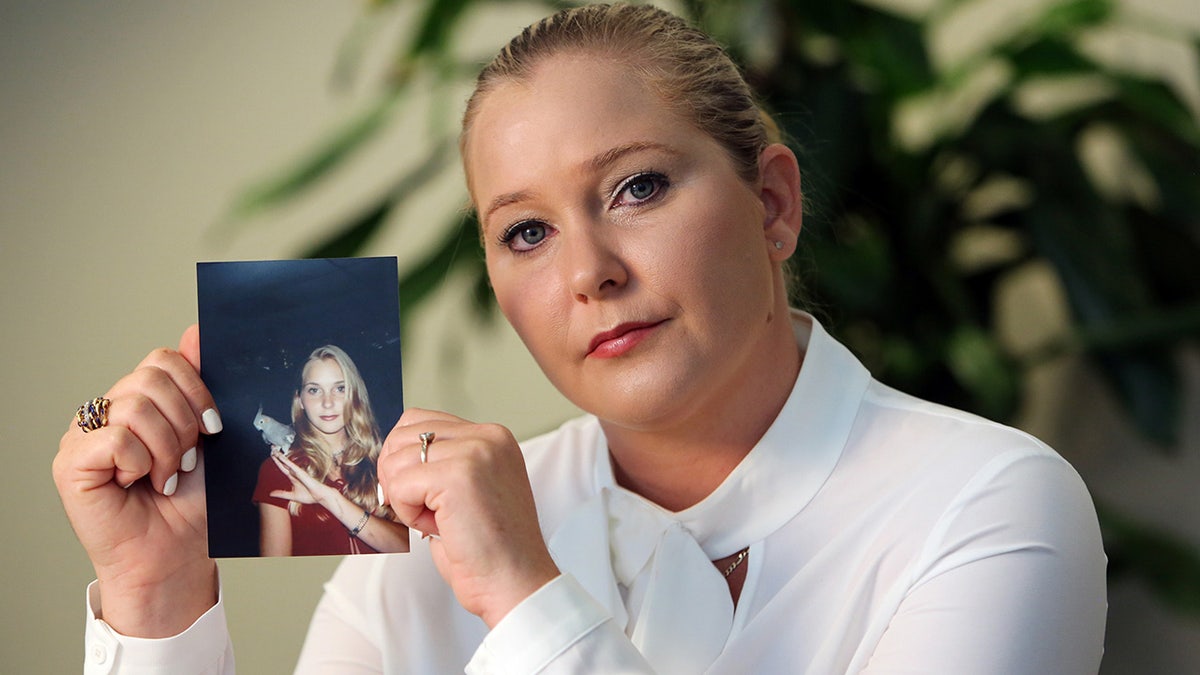 Virginia Roberts holds a photo of herself