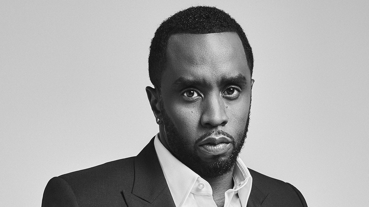 Sean Diddy Combs poses for portrait session wearing black suit.