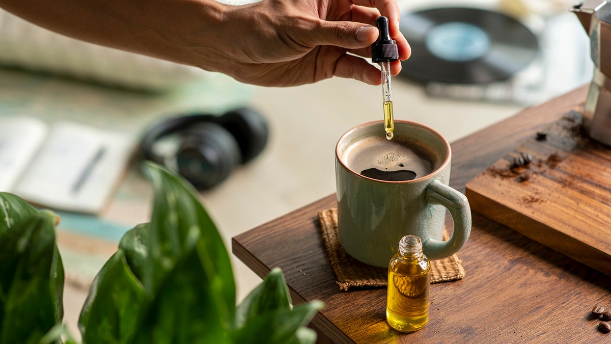 drops of oil are added to a coffee cup