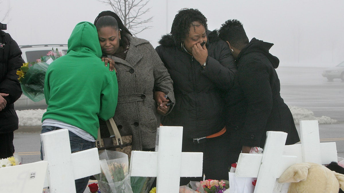 Mourners gather near the Lane Bryant store at the Brookside Market shopping mall on Monday, February 4, 2008, in Tinley Park