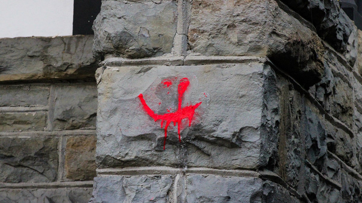 Spray paint is seen on the exterior of Cornell University’s Chi Phi fraternity house earlier this week.