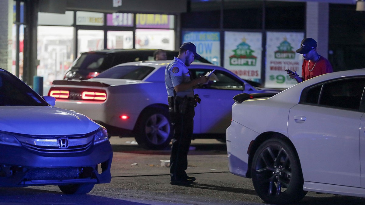 Police officer taking report in parking lot