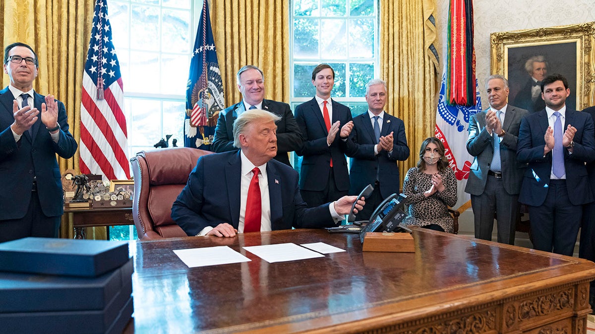 President Donald Trump hangs up after a phone call in the Oval Office of the White House, Friday, Oct. 23, 2020, in Washington. 