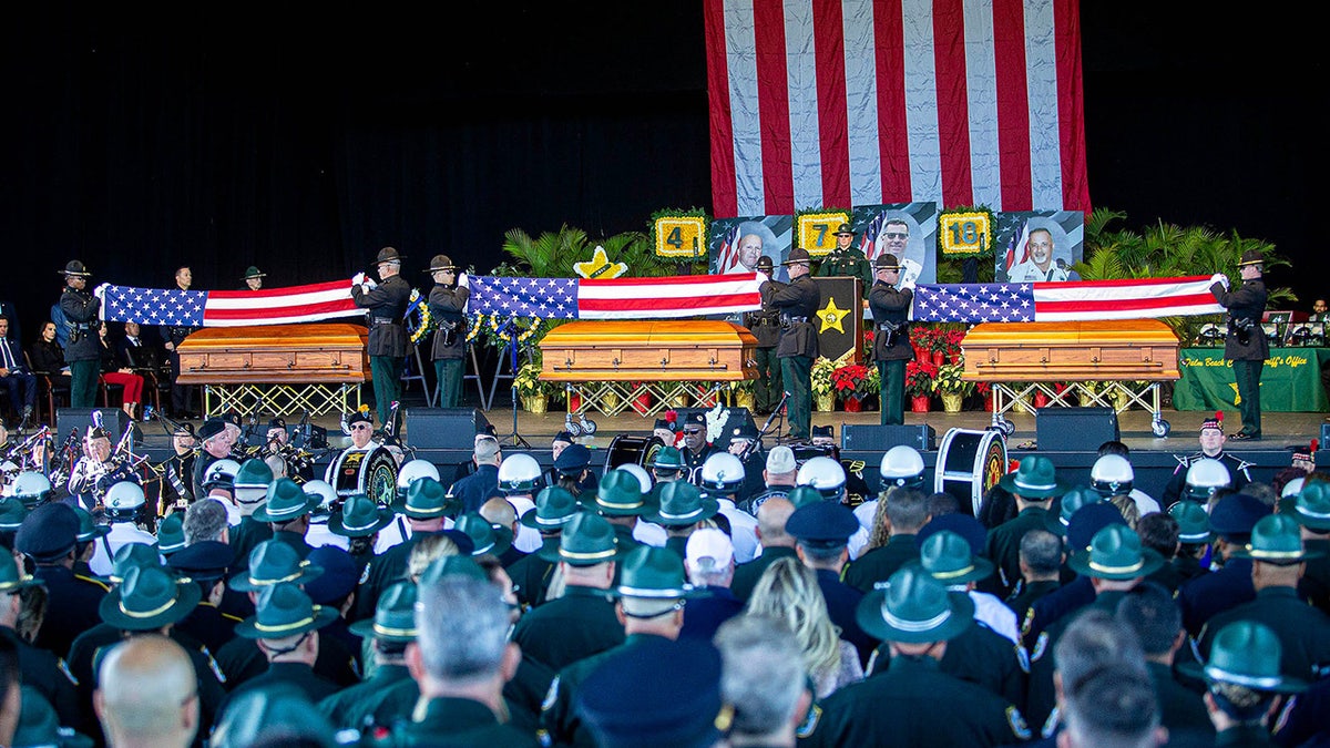 President Donald J. Trump, a secret service member, his son Donald Trump Jr., Florida Governor Ron DeSantis and his wife Casey DeSantis attend a memorial service for three fallen Palm Beach County Sheriff's deputies