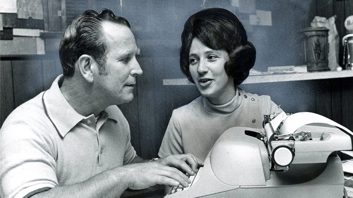 Edward Wayne Edwards with a woman in front of a typewriter