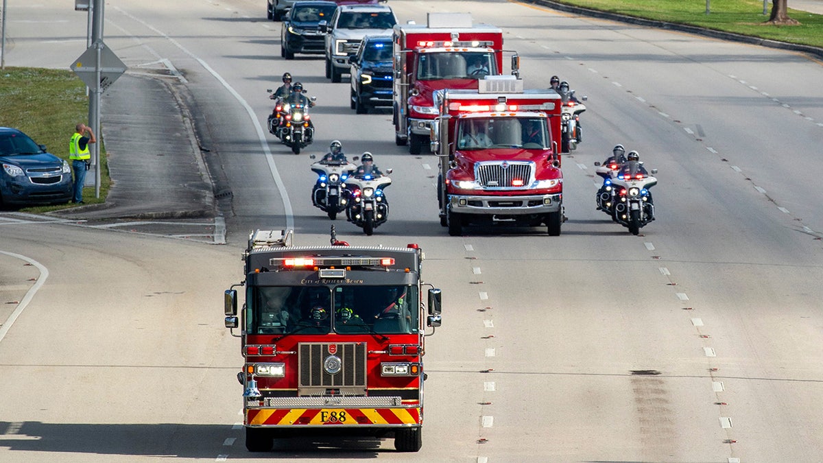 Rescue vehicles carry the two Palm Beach County Sheriff's Office deputies from the motorcycle unit who were struck and killed by a vehicle