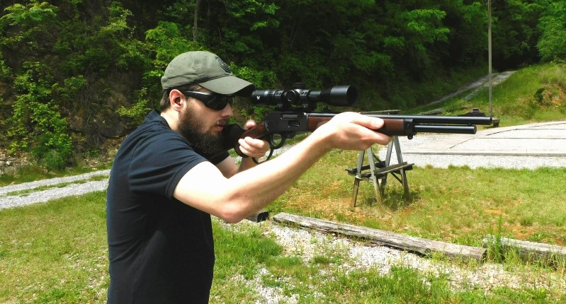 Man firing a lever action rifle