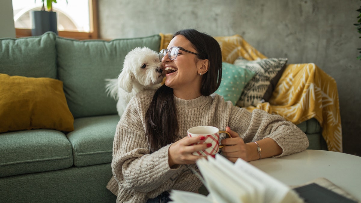 A young woman with her dog at home