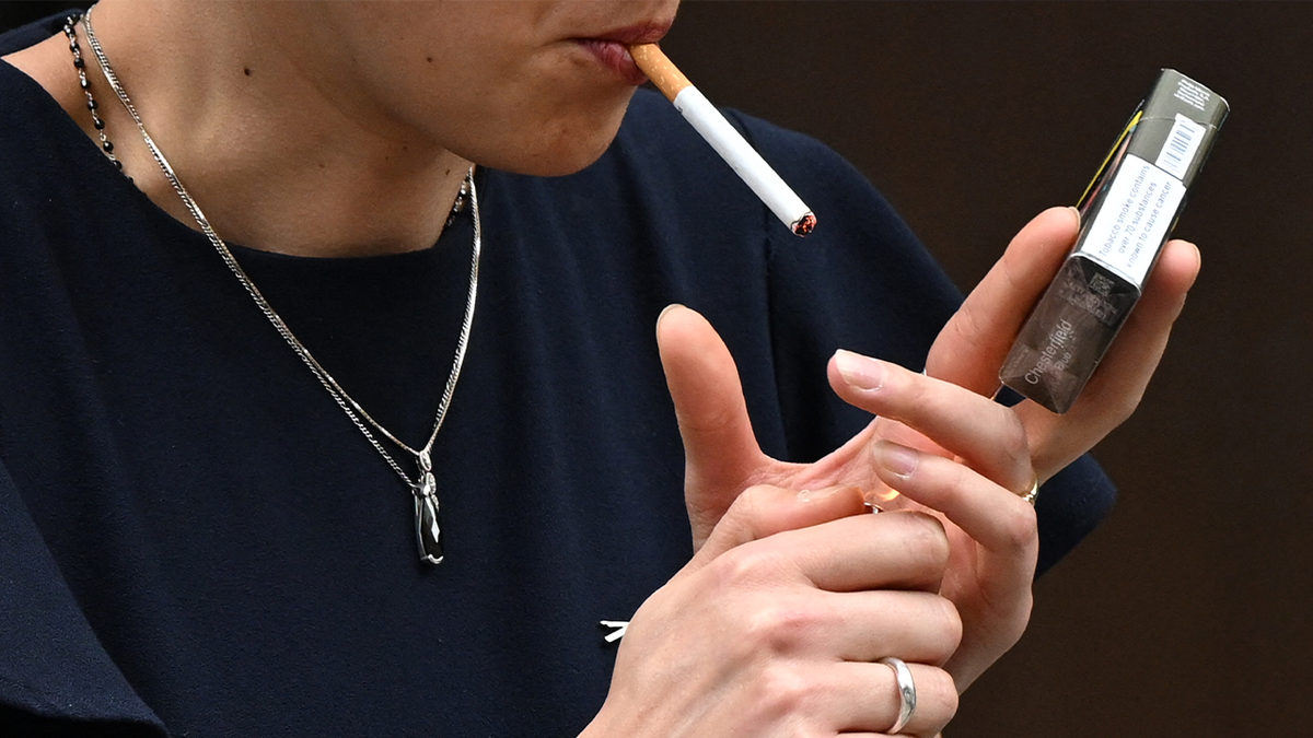 stock image of woman lighting a cigarette