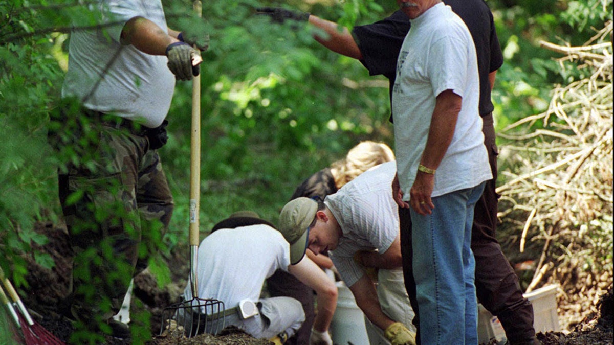 Investigators searching on the Fox Hollow Farm grounds.