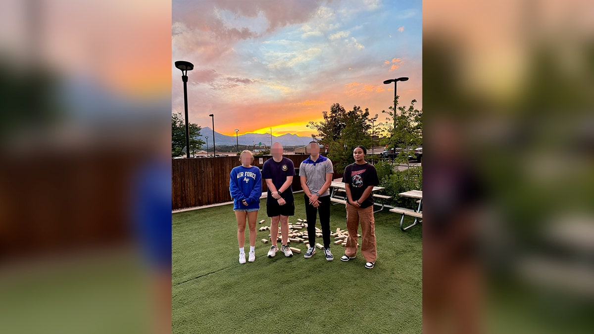 Ava moore photographed with friends with sun setting and mountains in background