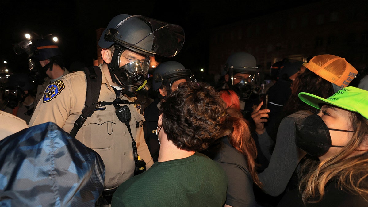 A police officer comes face-to-face with a protester at UCLA in May 2024.