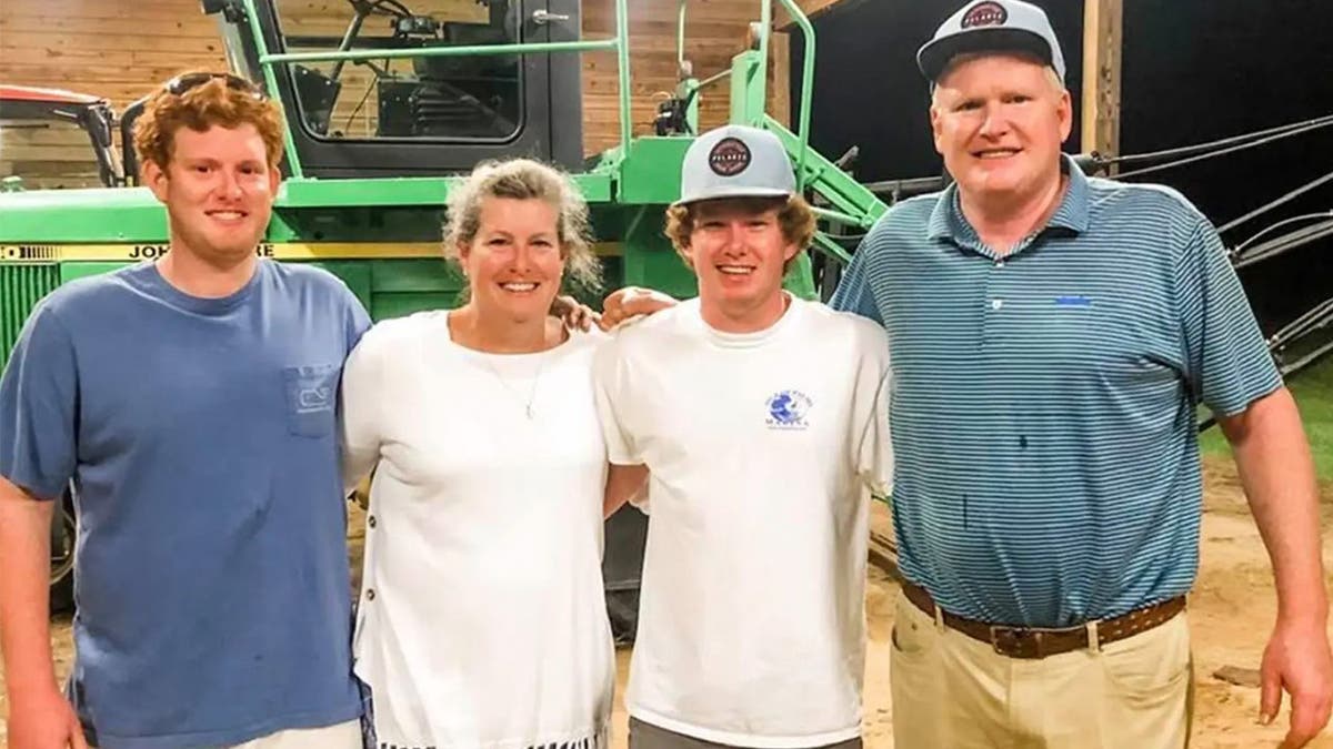 The Murdaugh family poses in front of a tractor.