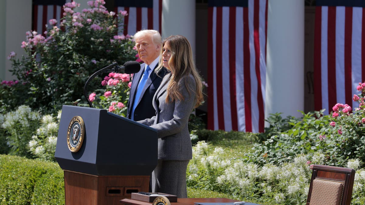 Melania Trump at lectern speaking, President Trump by her side