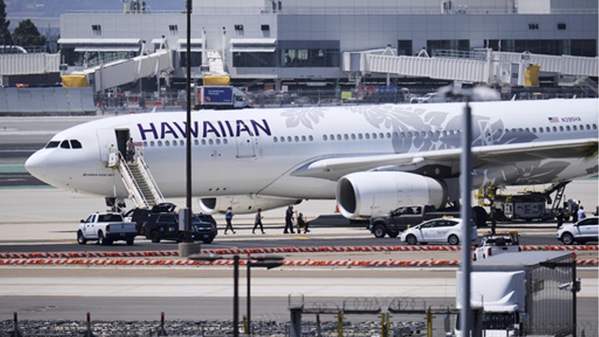 Hawaiian Airlines Flight 15 on the tarmac with officers walking out of plane