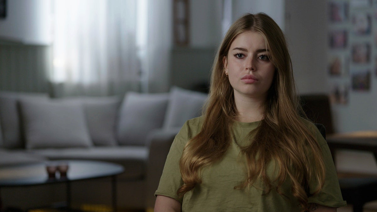 Jamie-Lee Arrow wearing an olive shirt and looking serious.