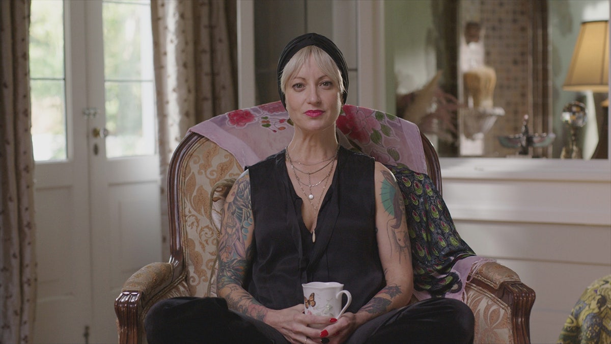 Suzanne Papini being interviewed while holding a teacup.