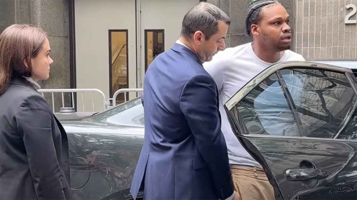 Miguel jiraud is led to an NYPD police car.