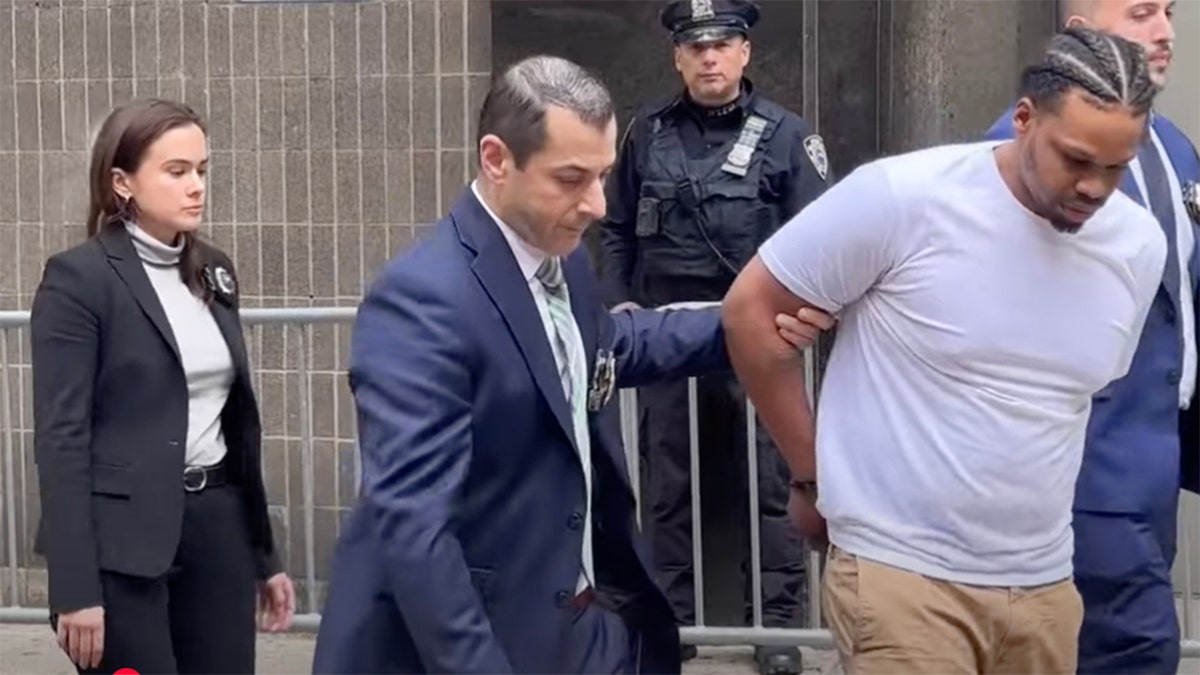 Miguel Jiraud being led by police.