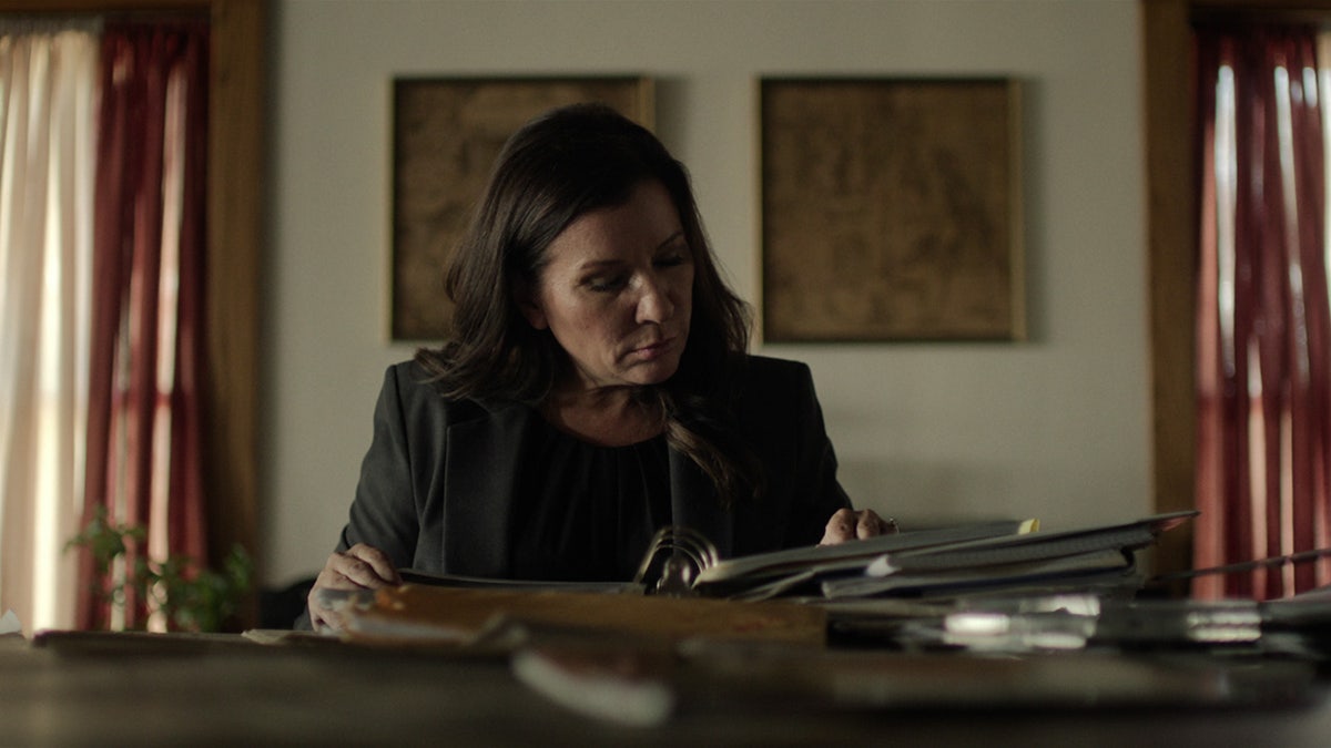 Michelle Rosen looking at newspaper clippings