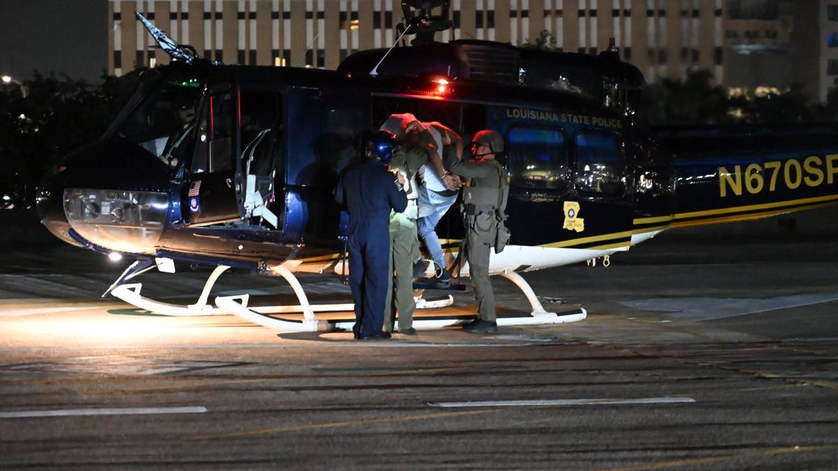 Gary Price escorted into police helicopter.