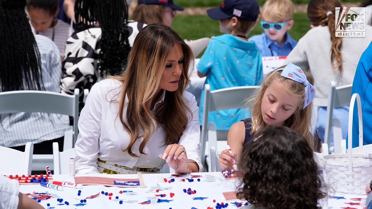 FLOTUS sits with children in the White House garden.
