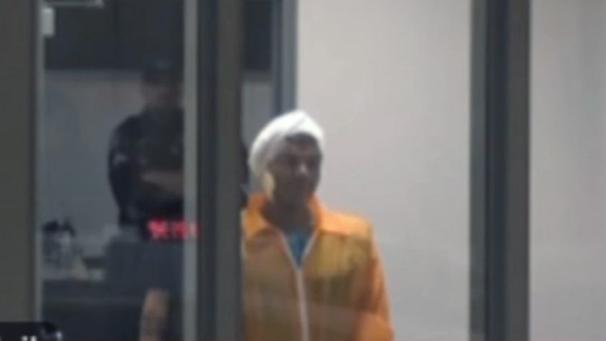 Mohamed Soliman in an orange jumpsuit