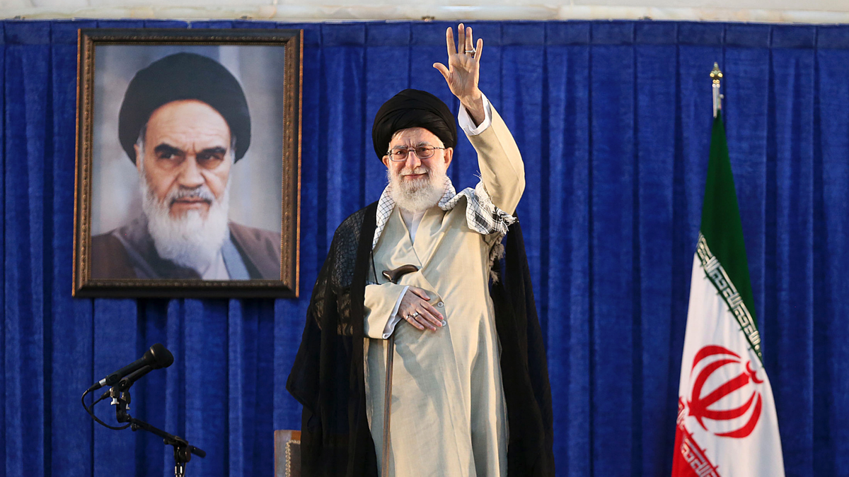 Supreme Leader Ayatollah Ali Khamenei waves to the crowd while attending a ceremony marking the 30th death anniversary of the late revolutionary founder Ayatollah Khomeini, shown in the poster at rear, at his mausoleum just outside Tehran, Iran, on Tuesday, June 4, 2019. Ayatollah Khamenei said his country will continue resisting U.S. economic and political pressure on his country.