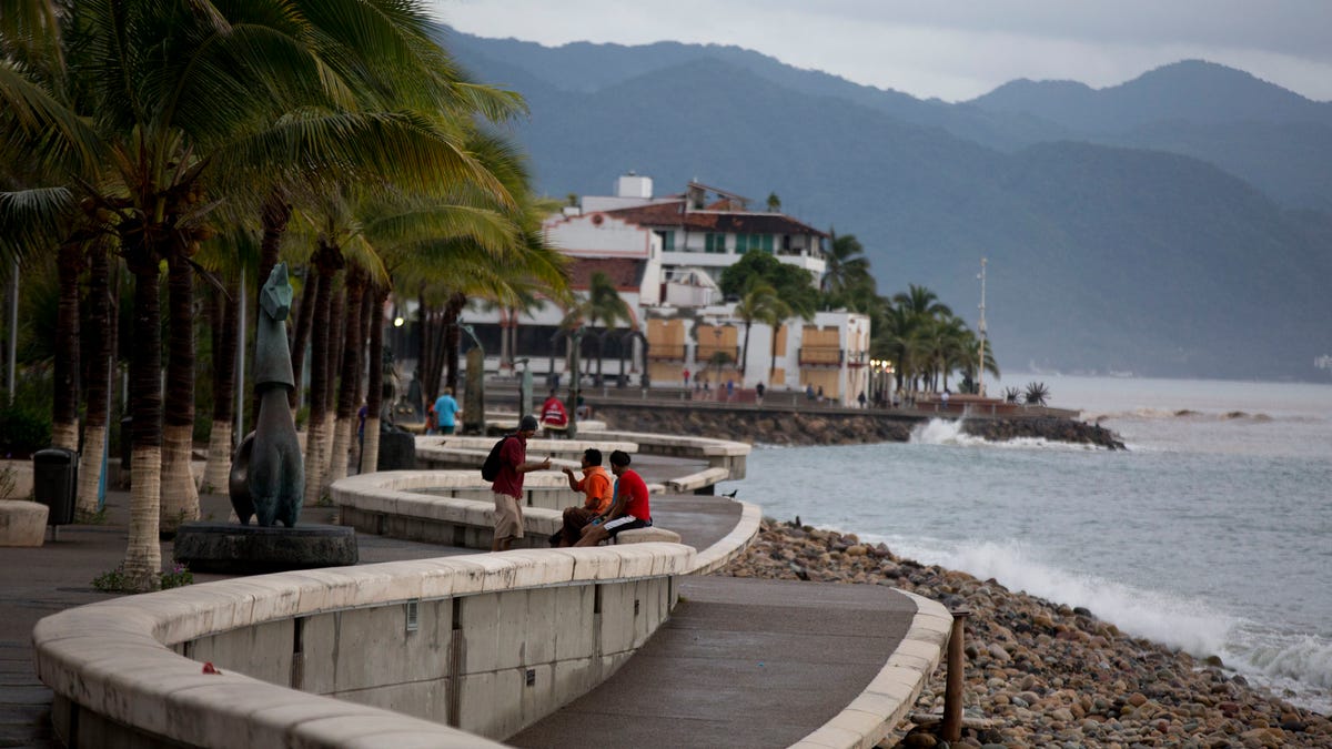 People enjoy a seafront walkway 