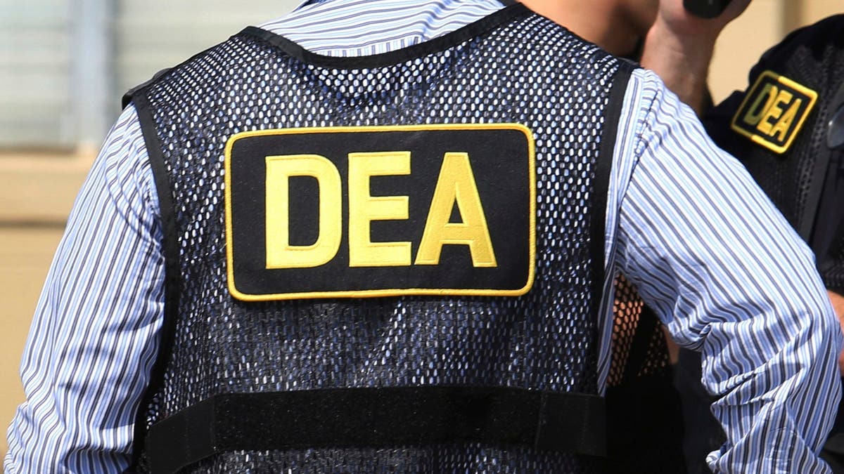 An agent wears a DEA vest