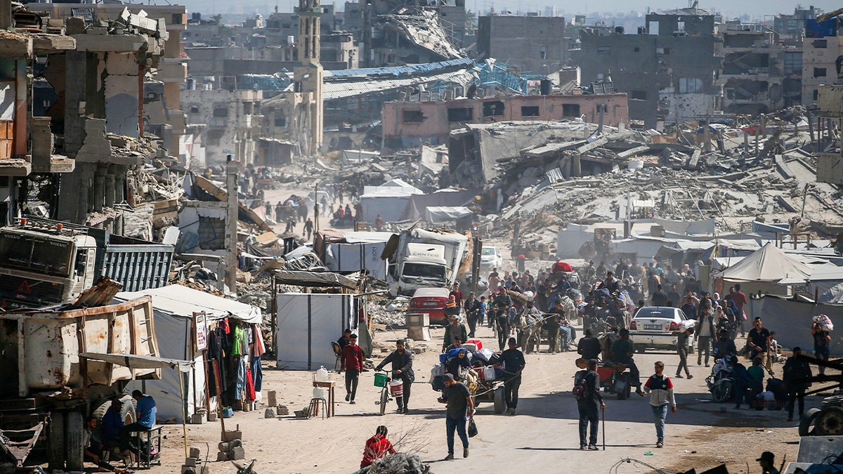 Palestinians make their way with belongings as they flee their homes after Israeli air strikes, in the northern Gaza Strip May 16, 2025.