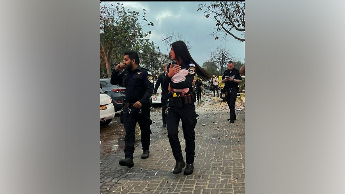 Ariel Levin-Waldman's baby Ayala carried by a police officer taking her to safety right after the house they lived in Rishon LeZion was hit by an Iranian missile attack.