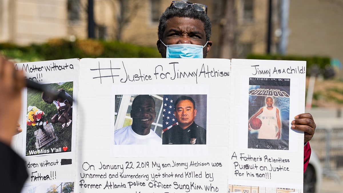 Jimmy Atchison's father holds a poster