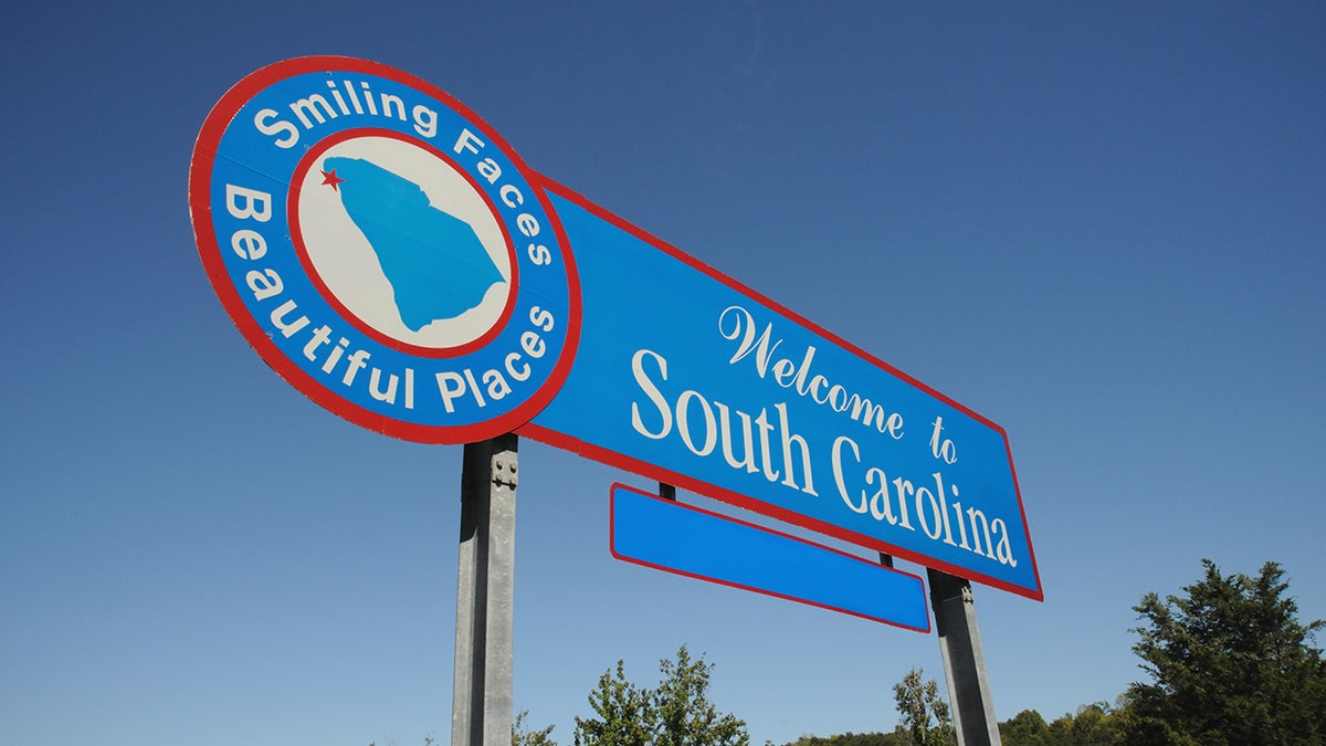 blue south carolina welcome sign which white lettering and red trim