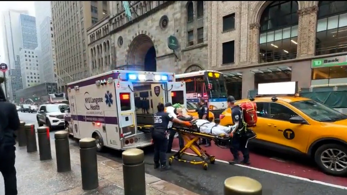 man in gurney being pulled into ambulence car