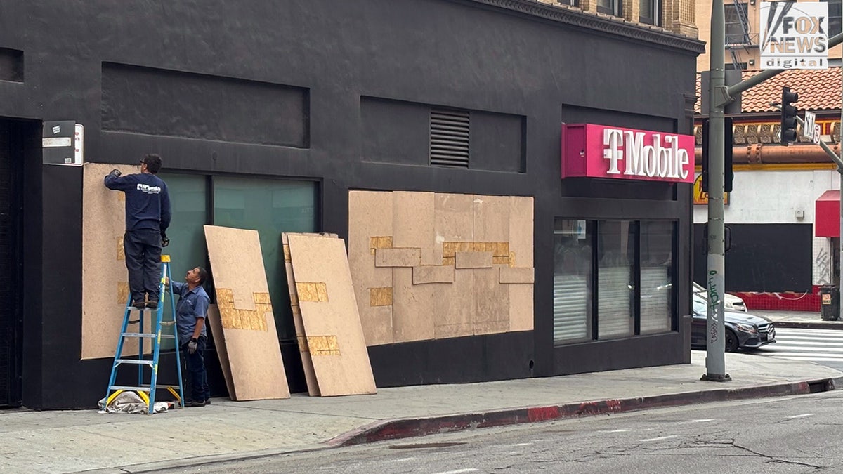 T-Mobile storefront being boarded up.