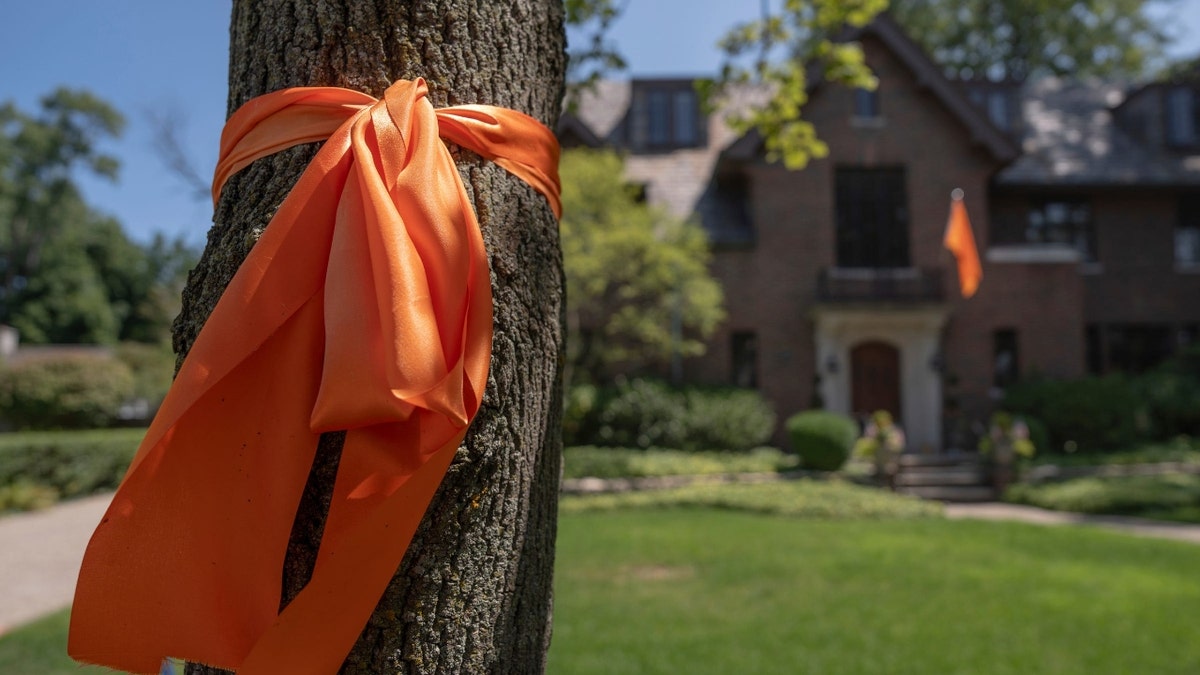 Orange ribbons are tied around trees all around the home of the late Flynn MacKrell in Grosse Pointe on Friday, July, 26, 2024.