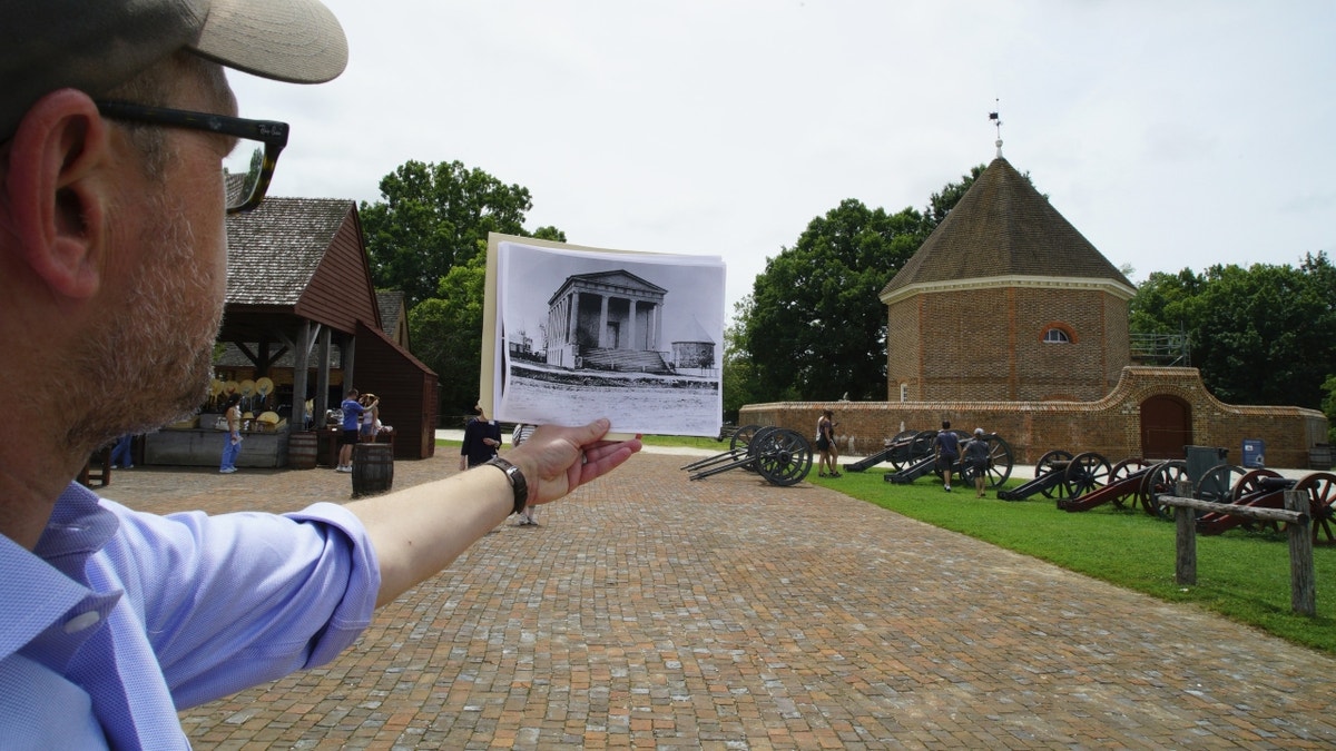 Man holding archival photo at Williamsburg