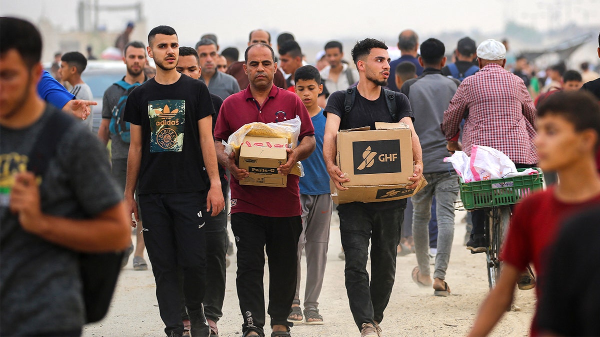 Palestinians carry aid from the Gaza Humanitarian Foundation