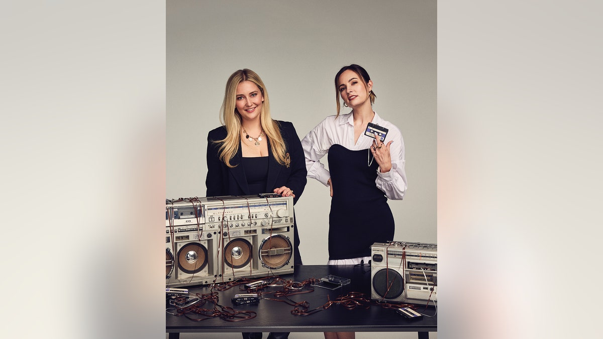 The hosts of Clues podcast posing together in matching black outfits.