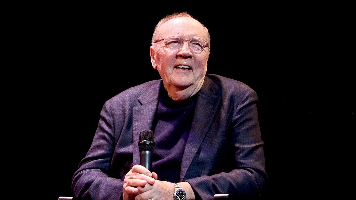 James Patterson smiling wearing a dark blue blazer and matching shirt.