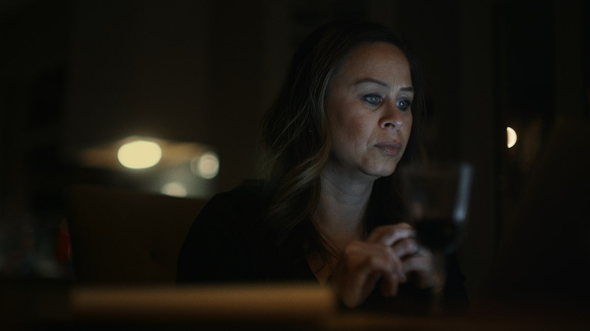 Misty Carausu looking deeply at a computer in a dark room.