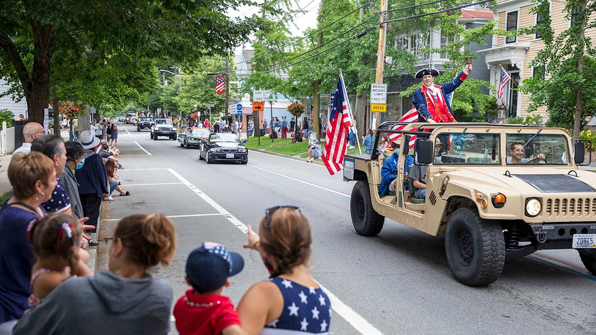 Spectators watch as a Fourth of July parade passes Saturday, July 4, 2020, in Bristol, R.I.