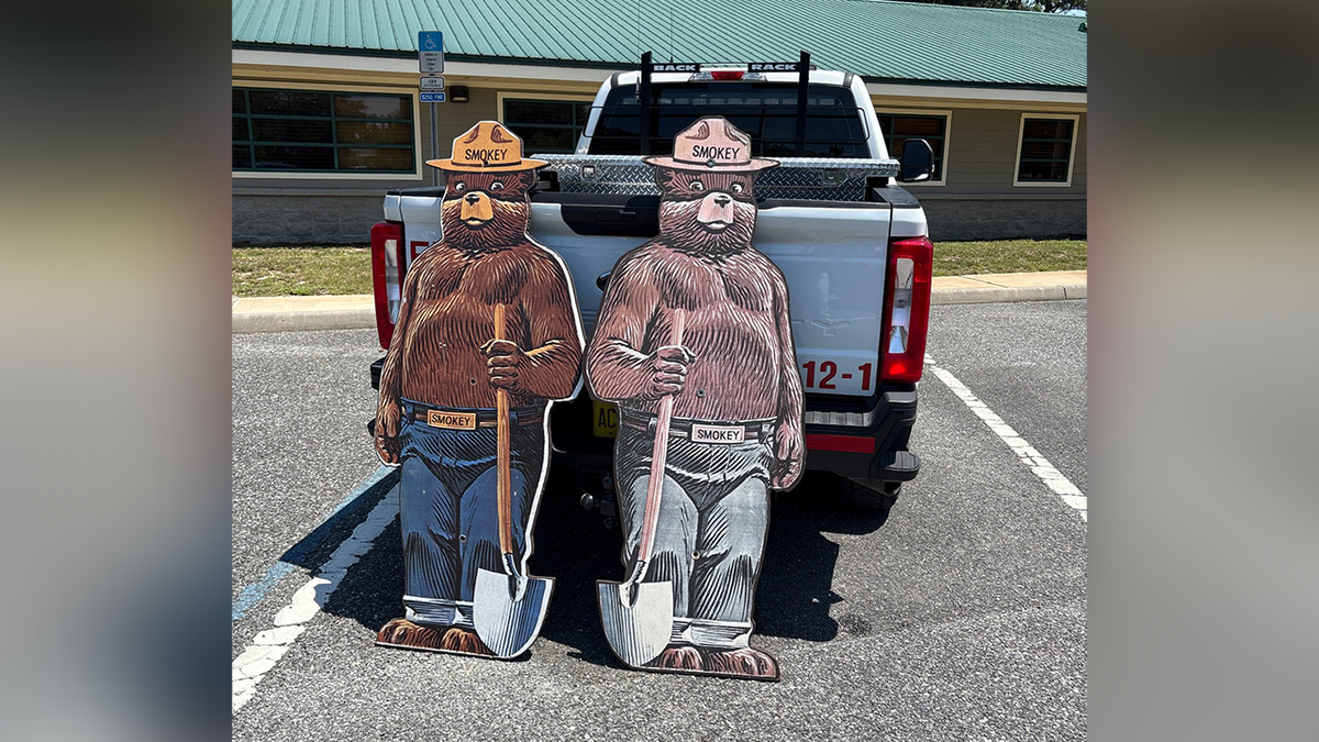 Smokey the Bears holding shovels