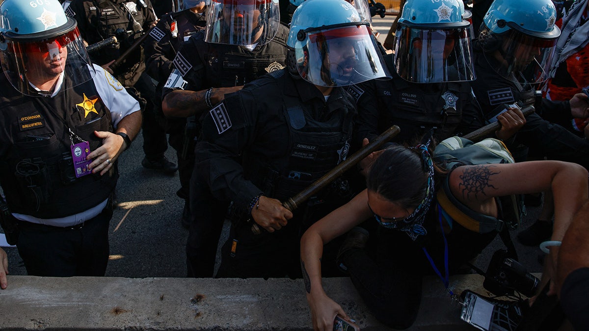 Riot police officers scuffle with demonstrators during the rally "March on the DNC" on the sidelines of the Democratic National Convention