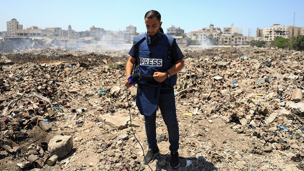 Al Jazeera journalist stands on landfill in Gaza