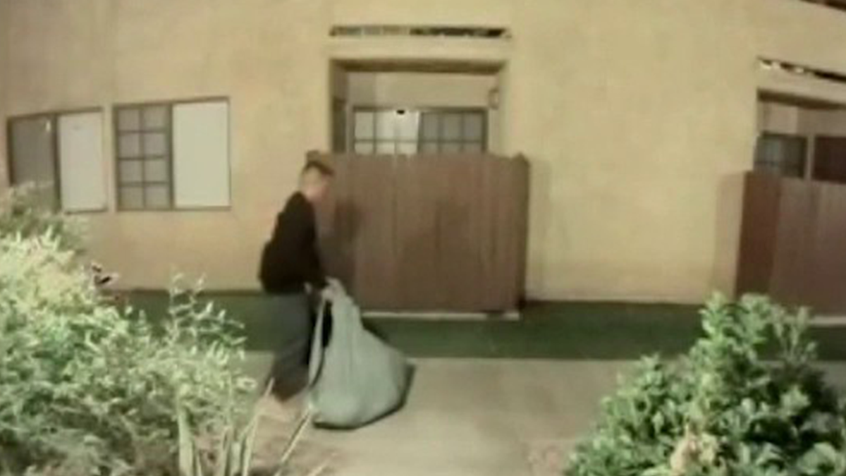 Jossimar Cabrera dragging a tarp believed to be containing his wife