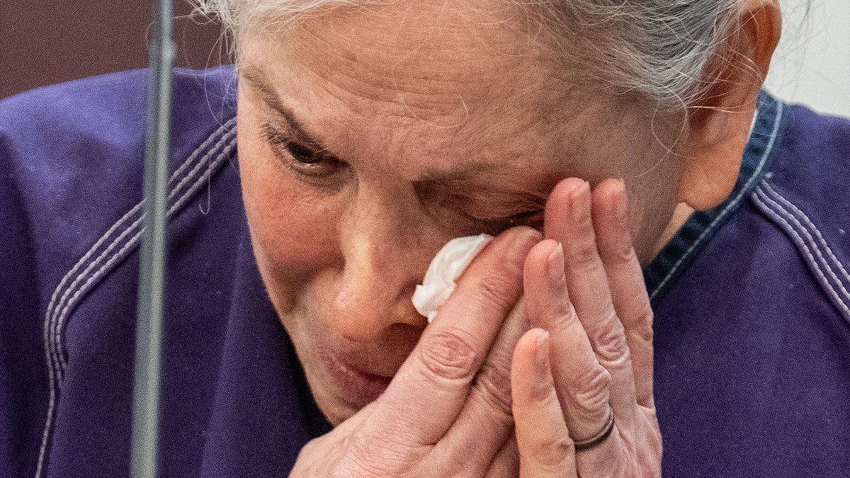 Donna Adelson using a tissue to wipe tears from her eyes